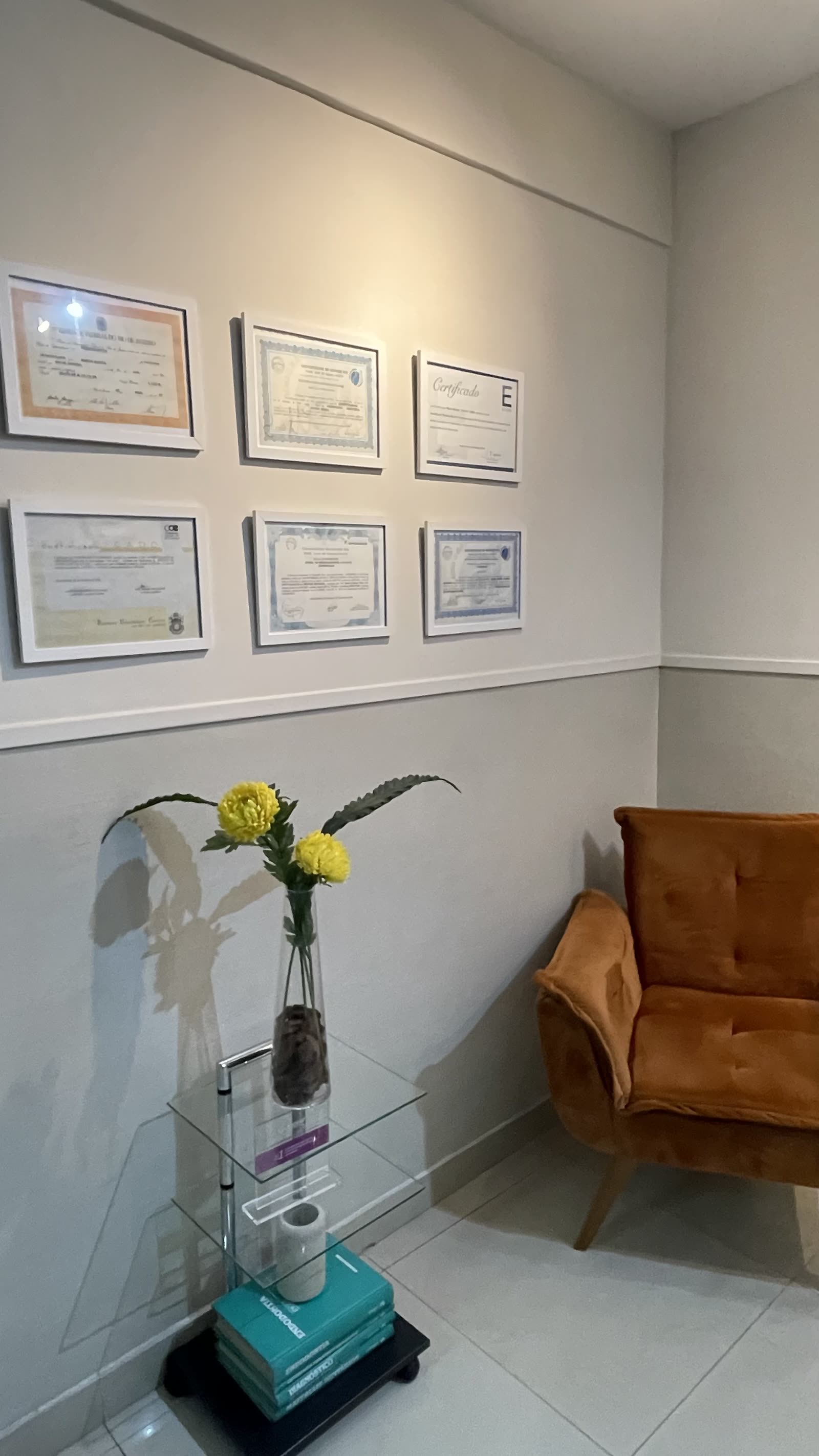 Parede com diplomas, certificados e cursos da equipe clínica